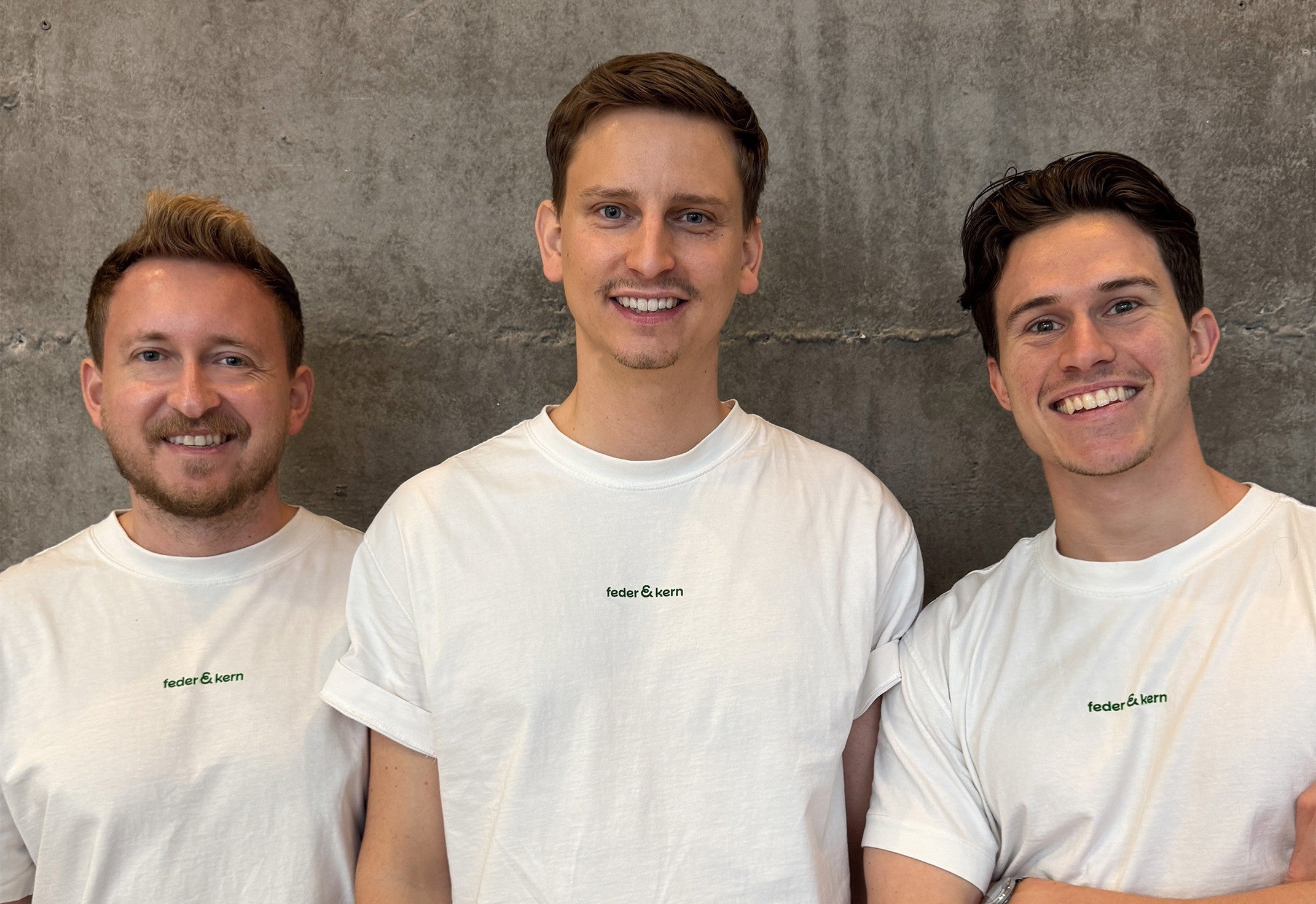 Feder & Kern Teamfoto, drei Männer im weißen Feder & Kern Shirt vor Betonwand, Peter, Tom, Cedric