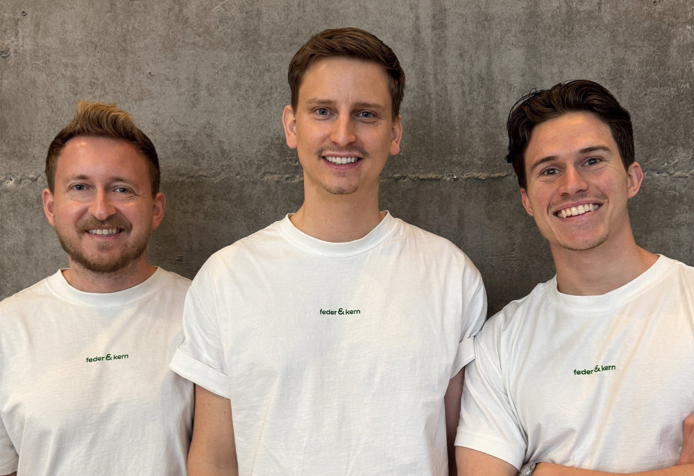 Feder & Kern Teamfoto, drei Männer im weißen Feder & Kern Shirt vor Betonwand, Peter, Tom, Cedric