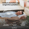 Ein Paar liegt entspannt auf einer Matratze im Schlafzimmer.