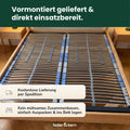 Feder & Kern Lattenrost aus Holz in einem Bettrahmen, vormontiert mit blauen Sicherungsbändern.